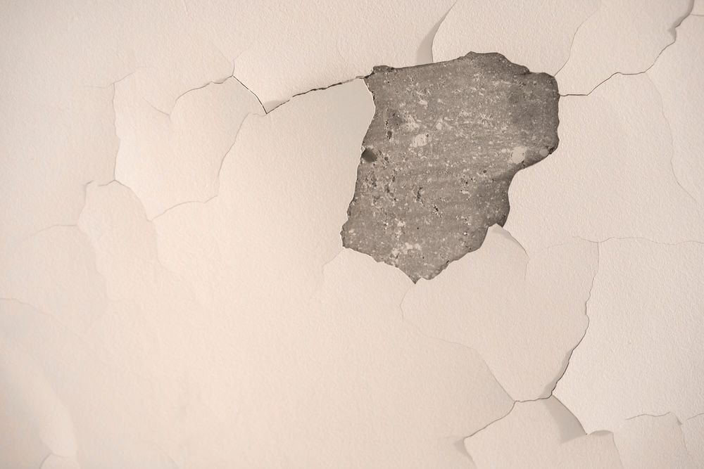A patch of off-white paint peeling away from a wall — RAC Carpentry Services in Pimpama, QLD