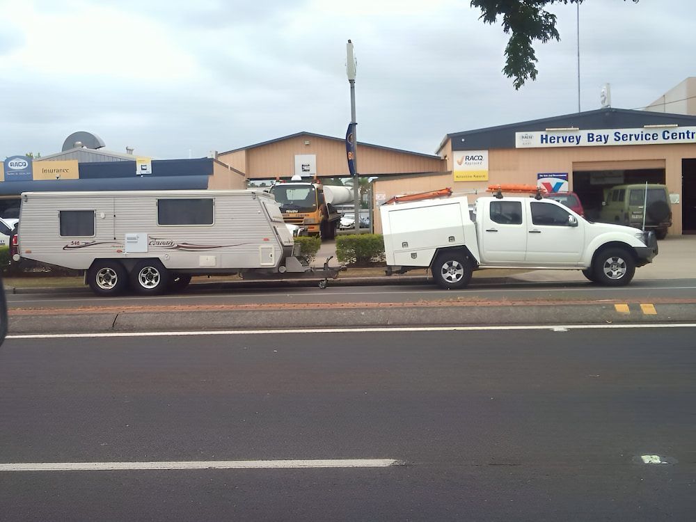 A White Truck With a Trailer Attached to It is Parked on the Side of the Road — Mr Shiny Mechanical in Andergrove, QLD