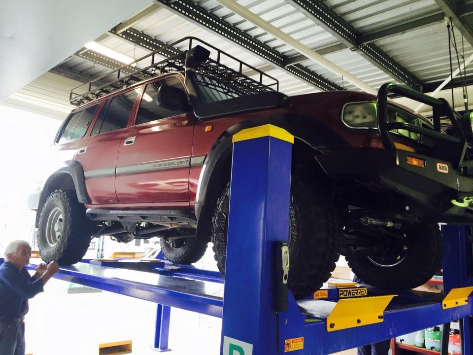 A Red Suv is on a Lift in a Garage — Mr Shiny Mechanical in Andergrove, QLD