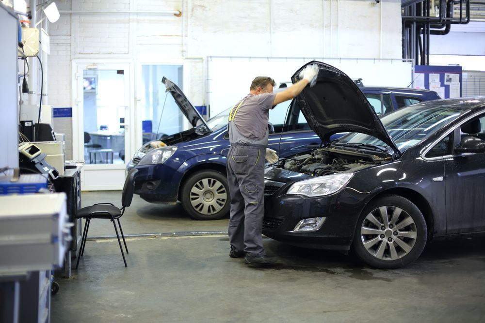 A Man is Working on a Car in a Garage With the Hood Open — Mr Shiny Mechanical in Paget, QLD