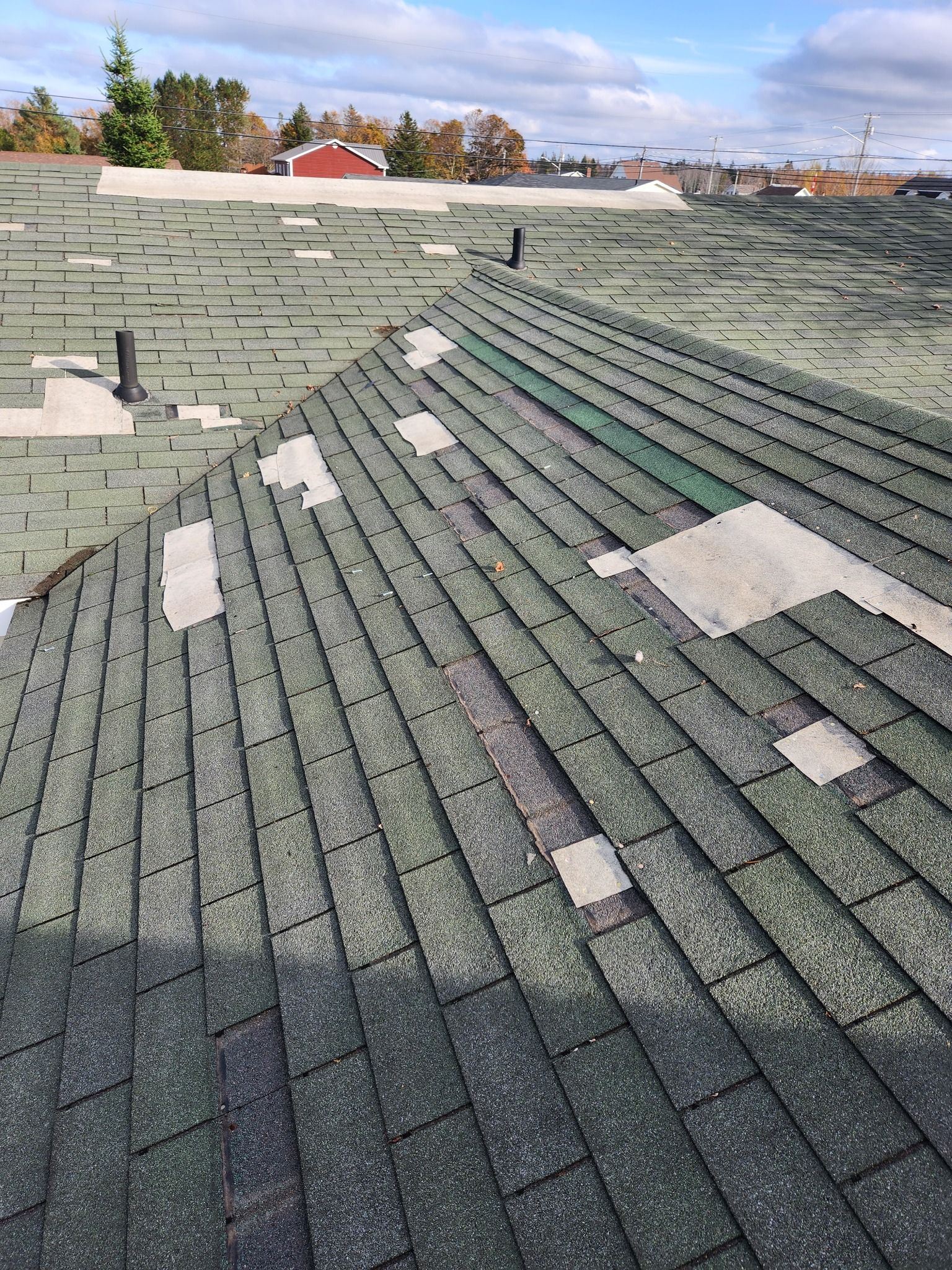 A close up of a roof with a lot of shingles missing.