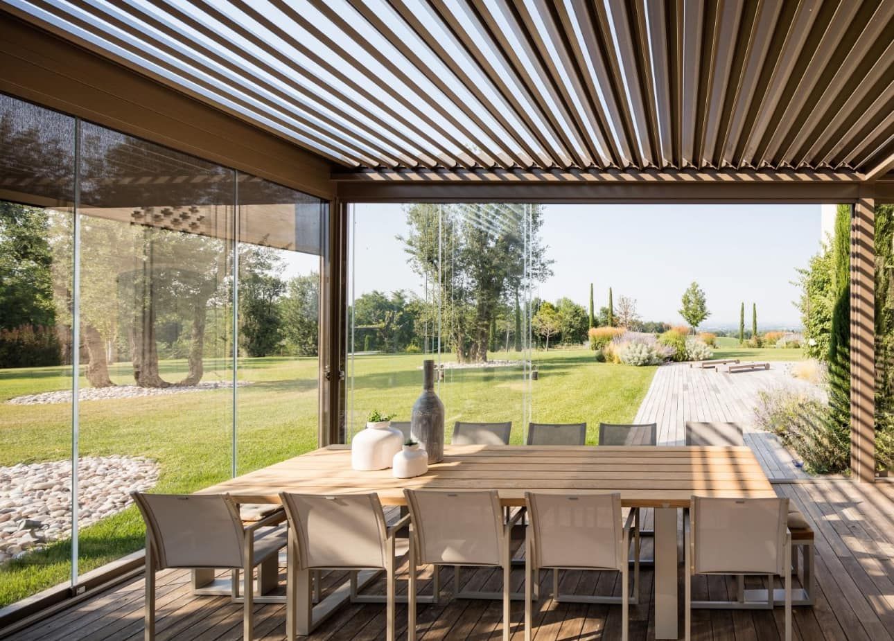 Una sala da pranzo con tavolo e sedie sotto un pergolato.