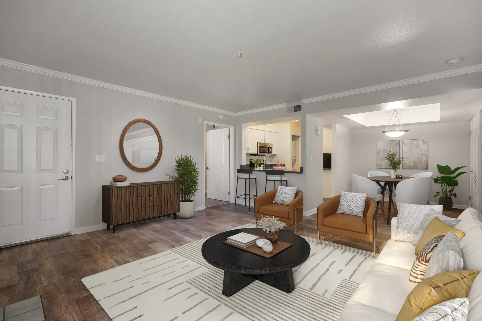 Open-concept living room in an apartment with a sofa, two armchairs, rug, and a kitchen bar at Marina's Edge