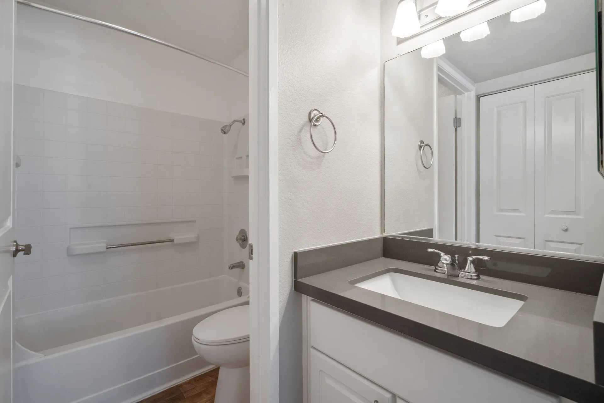 Bathroom with tub/shower combo, grab bar, toilet, and vanity with sink at Marina's Edge