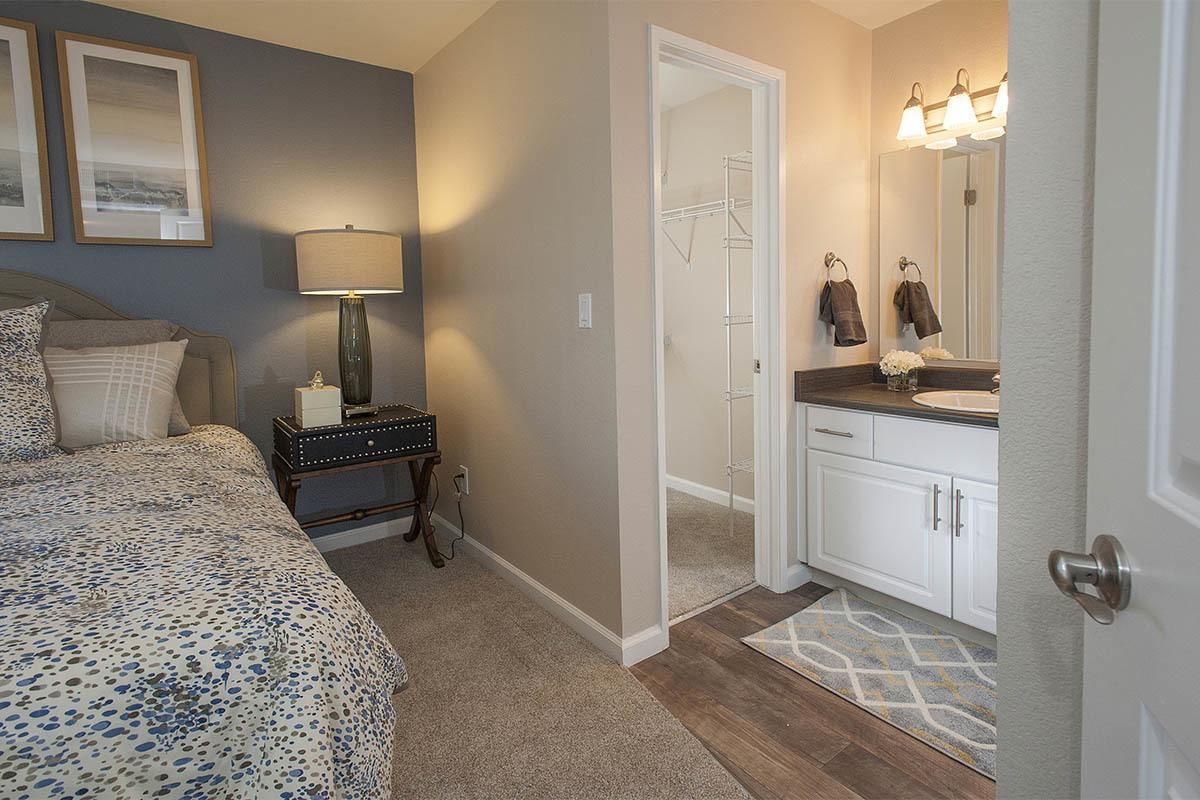 Bedroom with a queen bed, blue accent wall, and doorway to an en-suite bathroom at Marina's Edge
