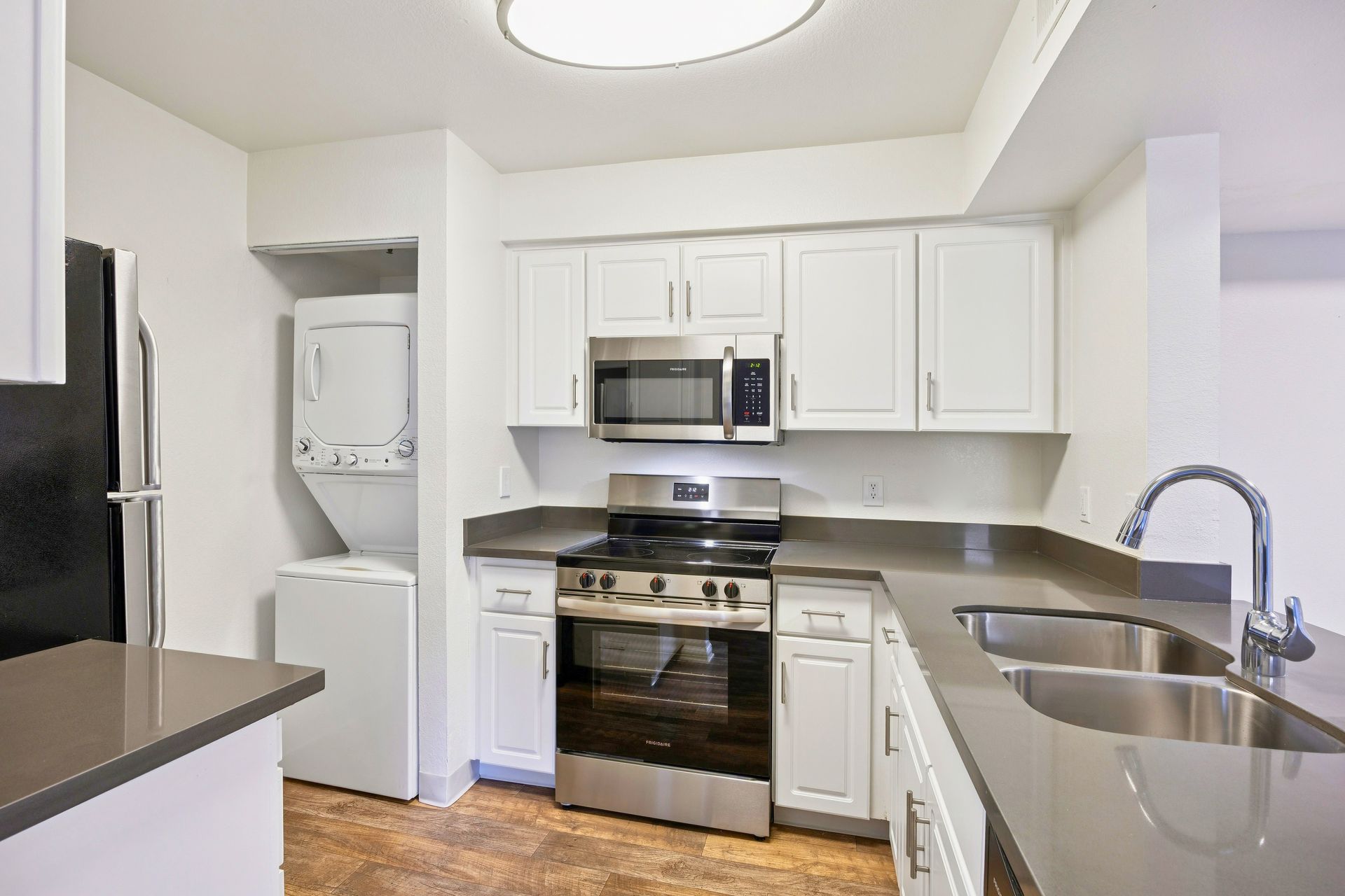 Renovated kitchen with quartz countertops & stainless steel appliances.
