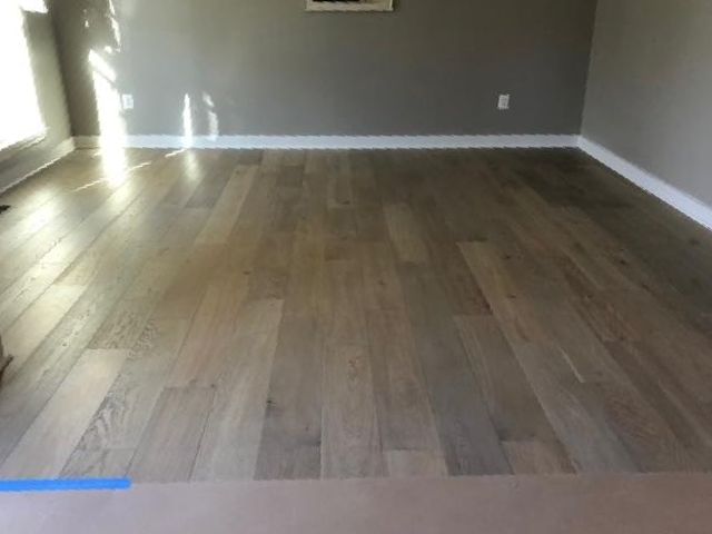 A living room with hardwood floors and gray walls
