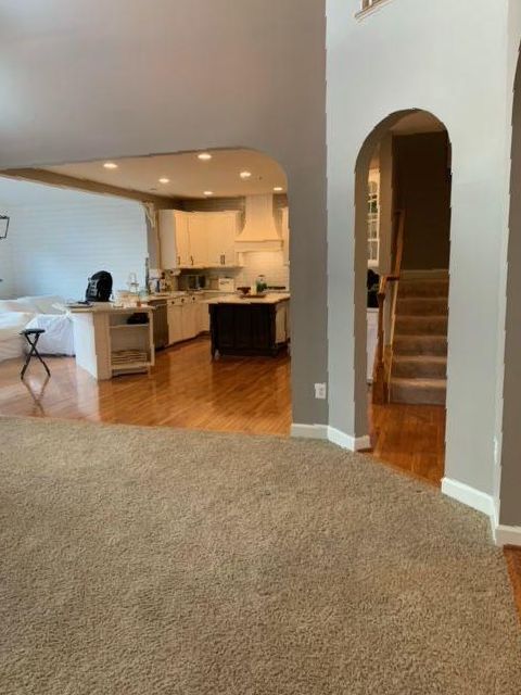A living room with a staircase leading to a kitchen