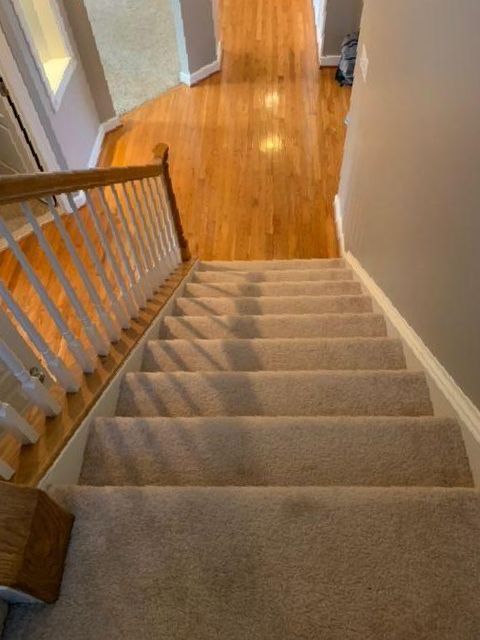 The stairs are carpeted and have a wooden railing.