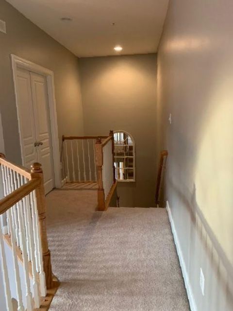 A hallway with stairs leading up to the second floor
