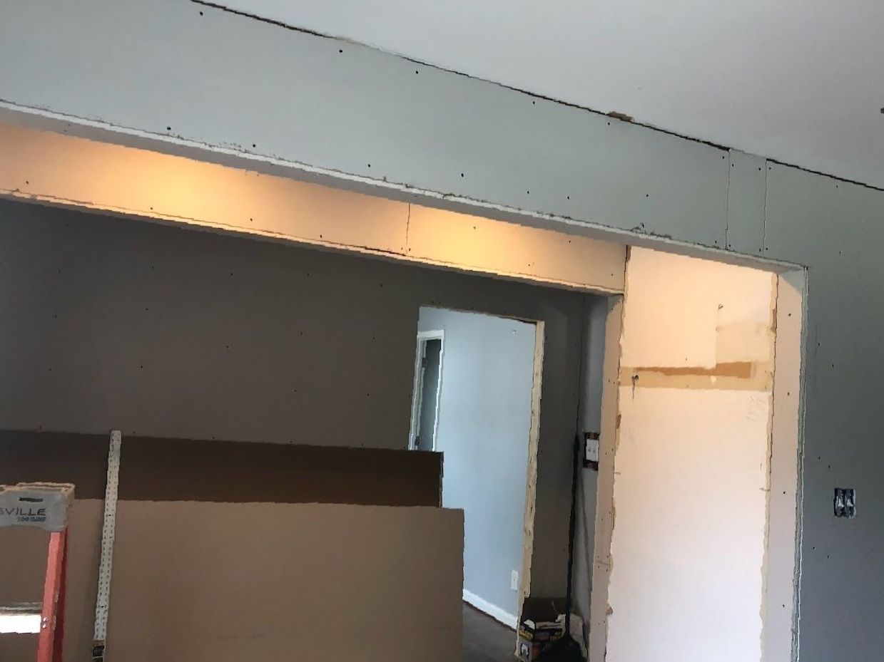 A room with a door and a ceiling that is being remodeled.