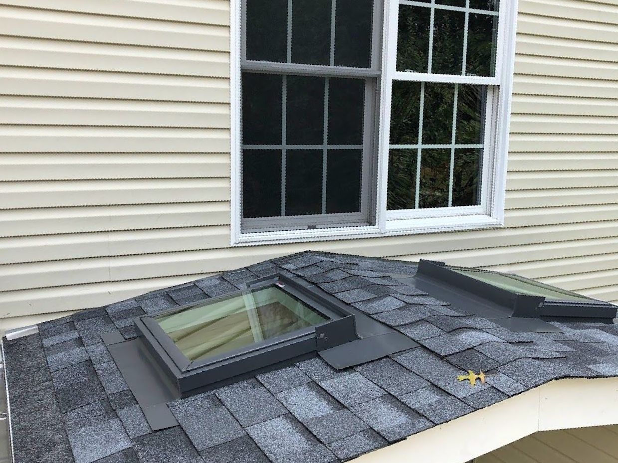 A house with two skylights on the roof and a window.