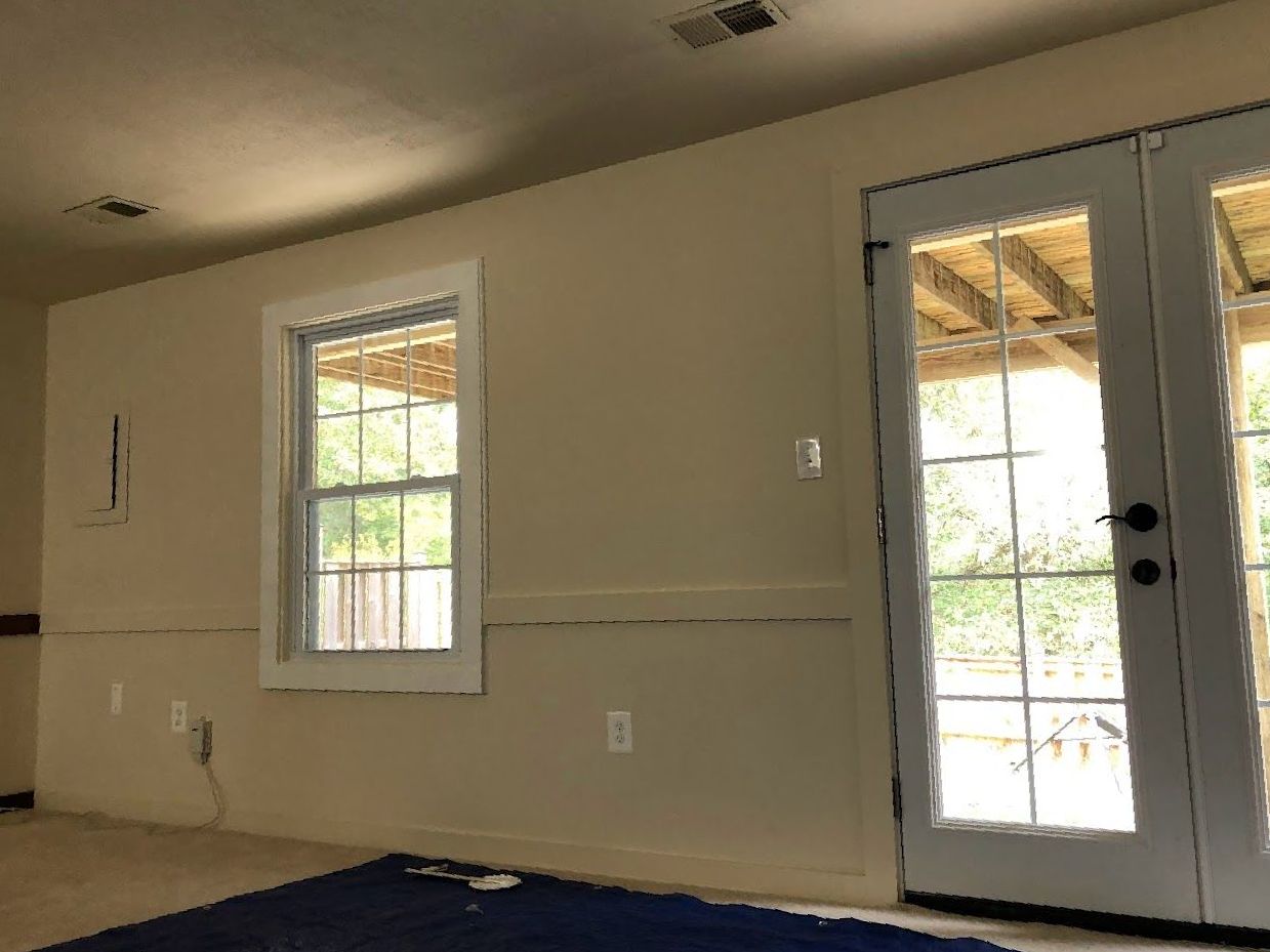 An empty room with two windows and a door.