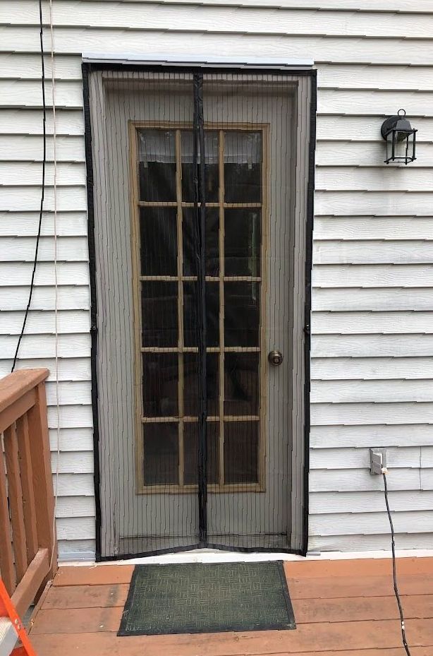 A sliding glass door with a screen on it is on a deck.