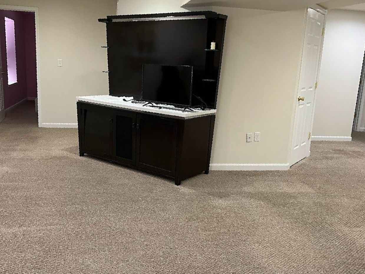 There is a television on the wall in the middle of the room.
