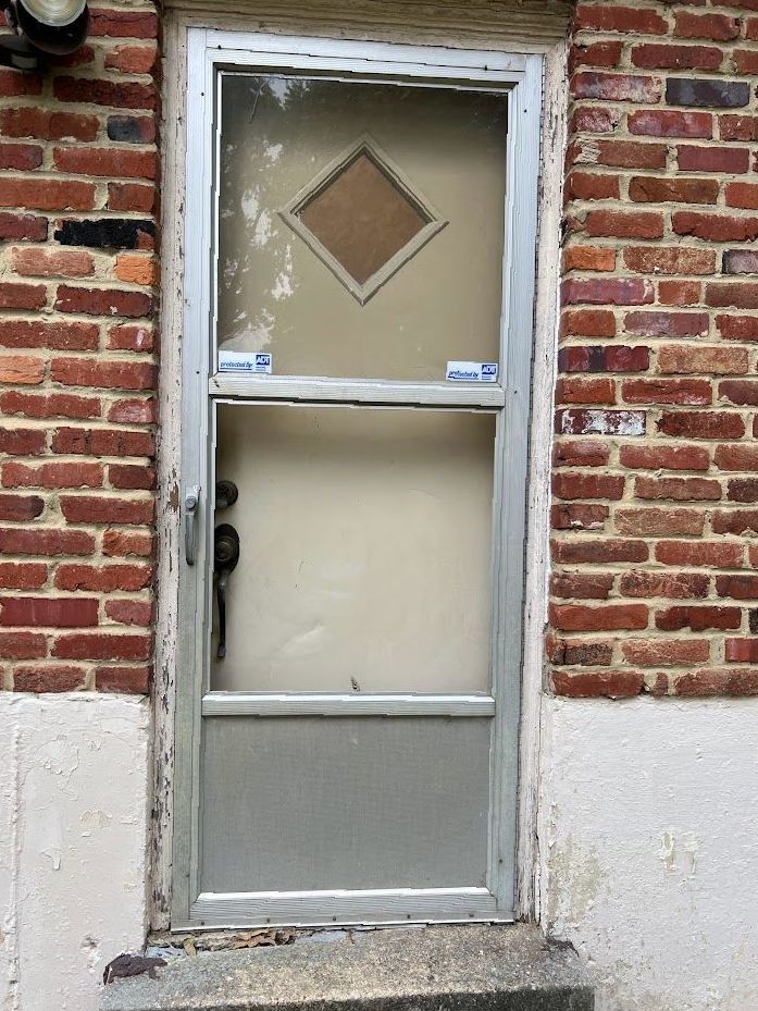 A brick building with a door that has a diamond design on it