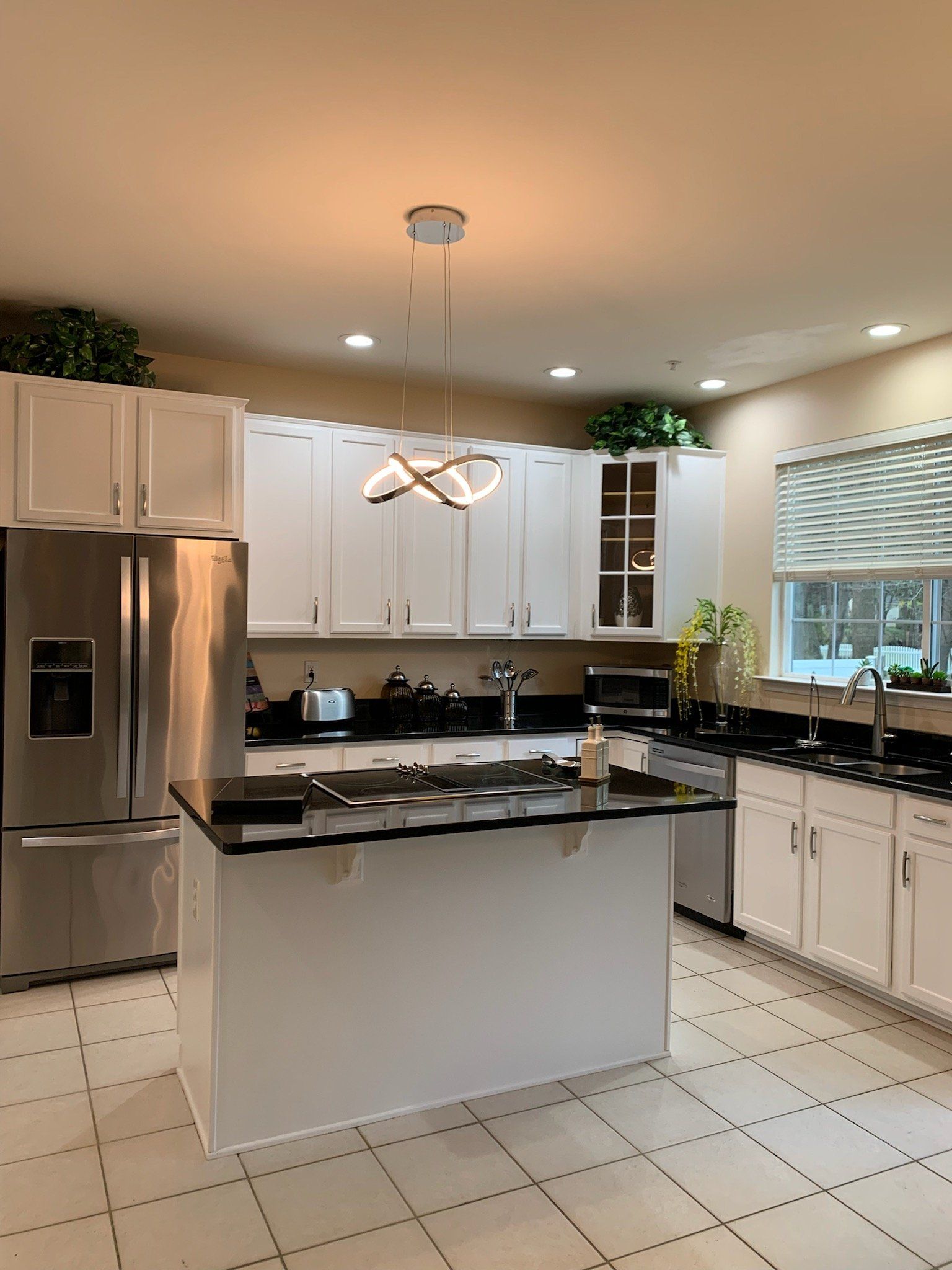A kitchen with white cabinets and stainless steel appliances