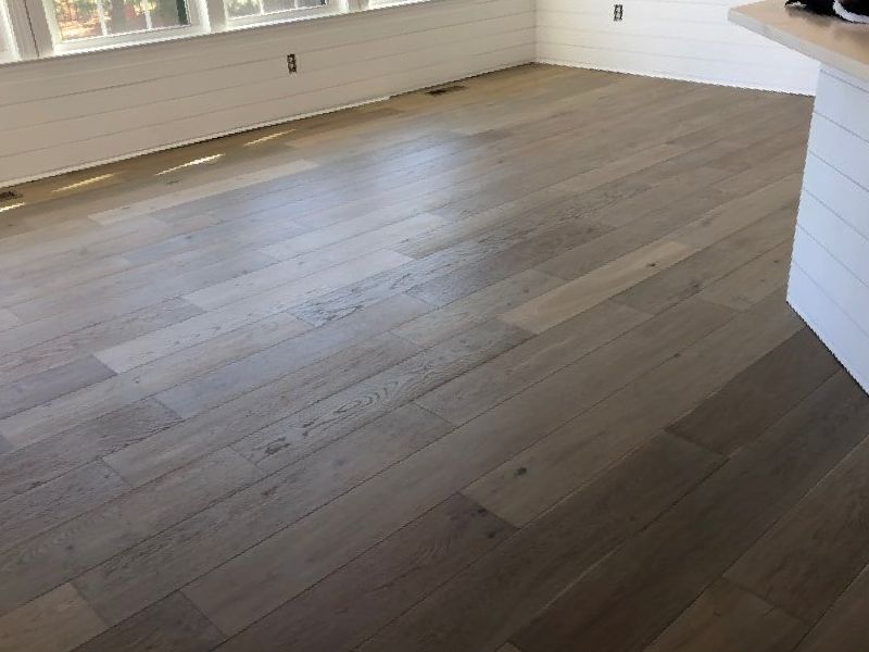 A living room with hardwood floors and white walls.