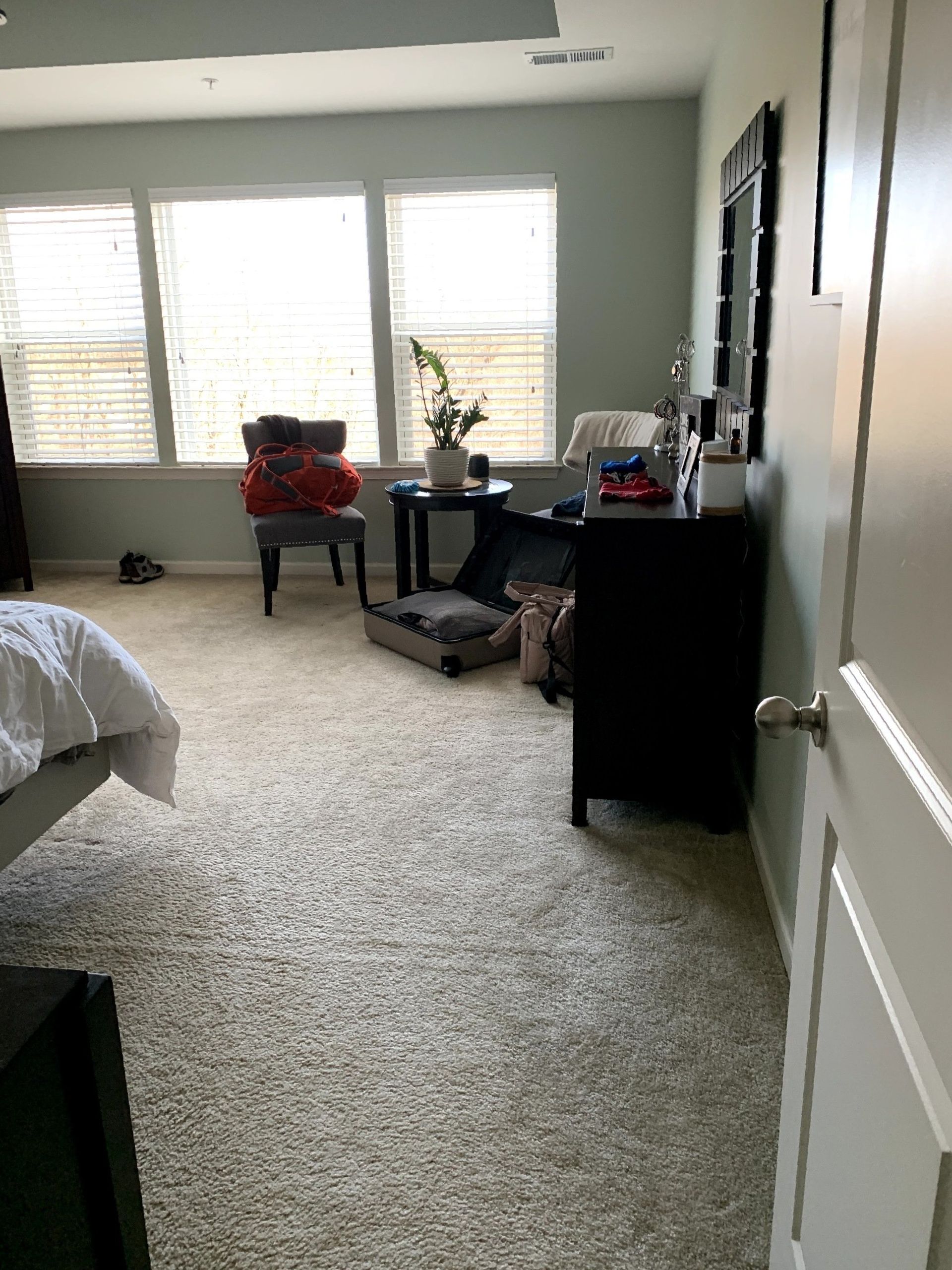 A bedroom with a bed , desk , chair and window.