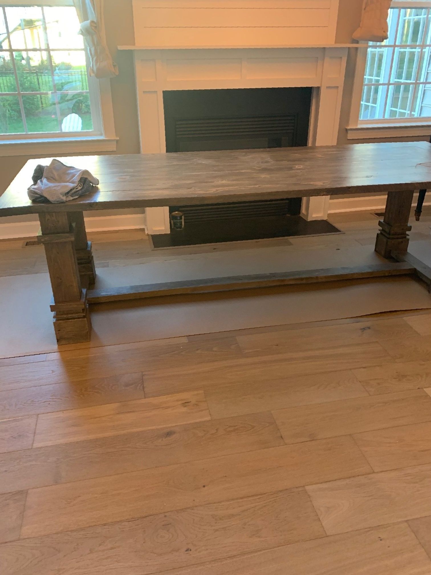 A wooden table is sitting in a living room next to a fireplace.