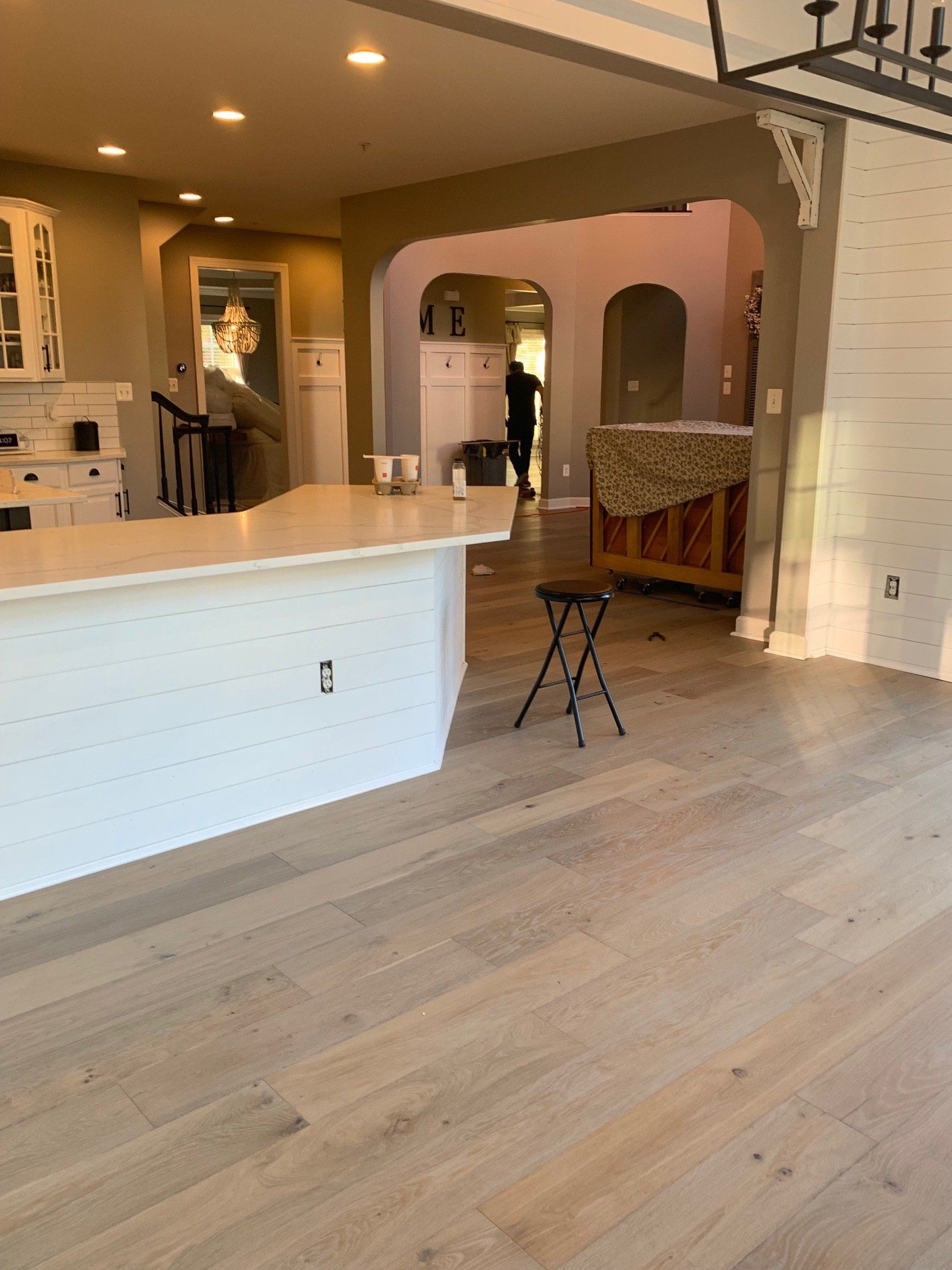 A kitchen with a white island and a wooden floor
