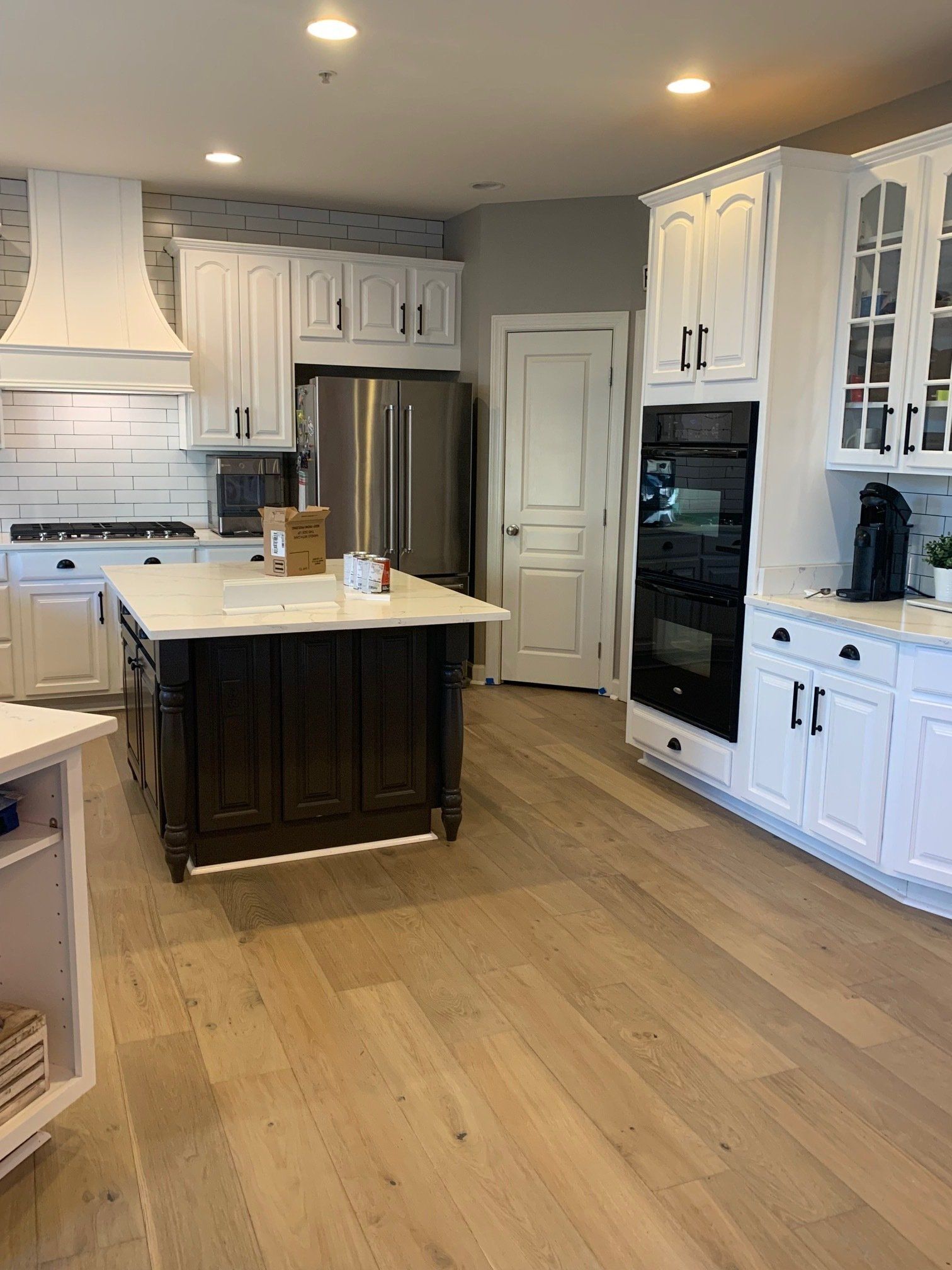 A kitchen with white cabinets and a large island in the middle.