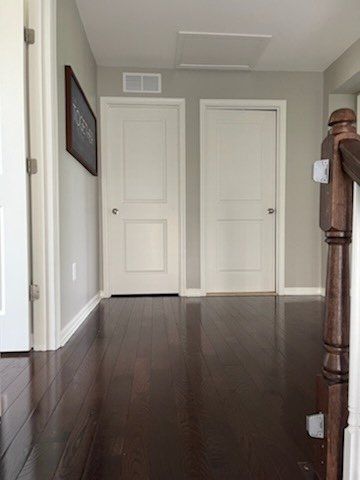 A hallway with hardwood floors and white doors in a house.