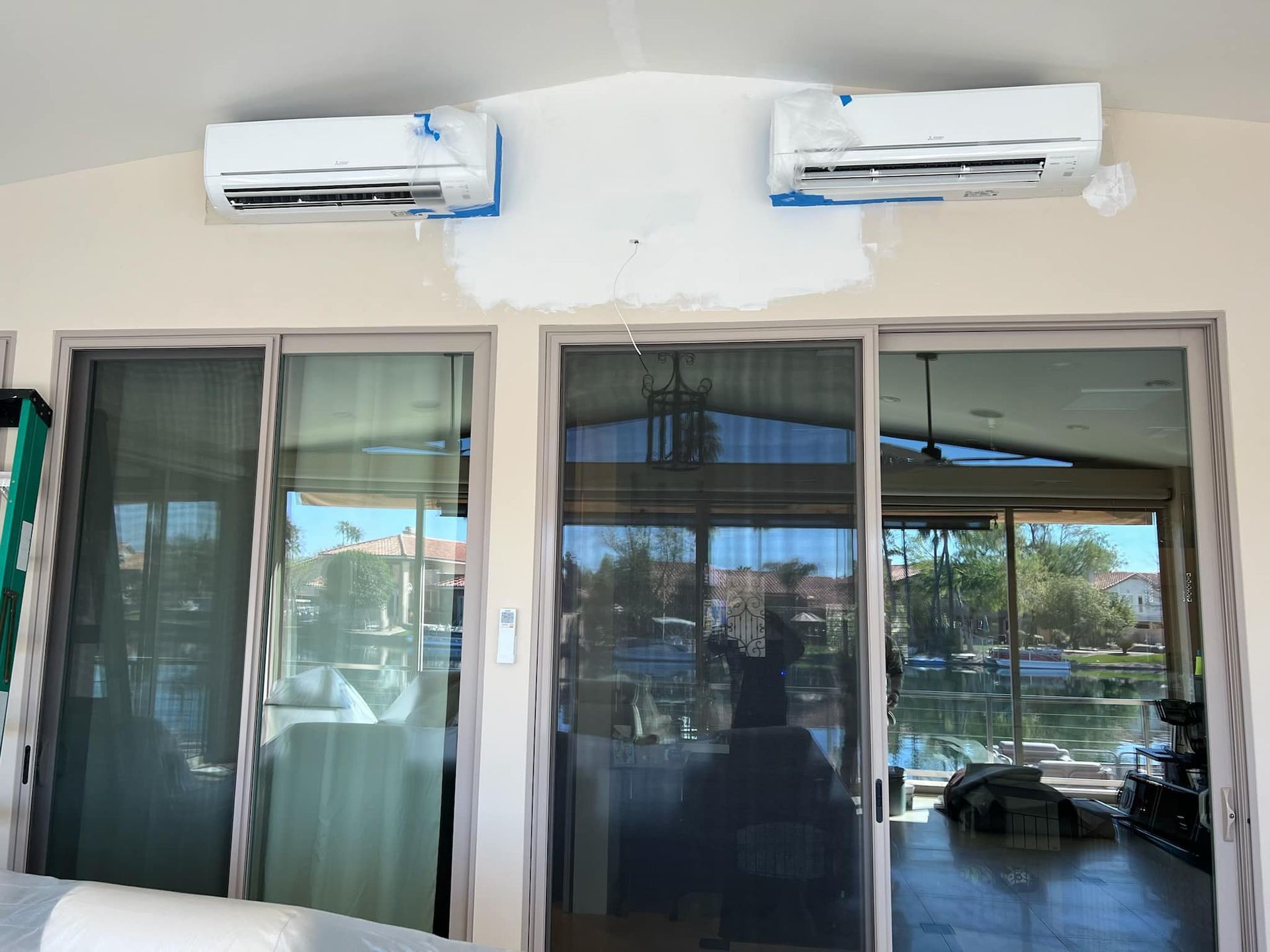 Storefront with glass sliding doors and two wall-mounted air conditioners above.