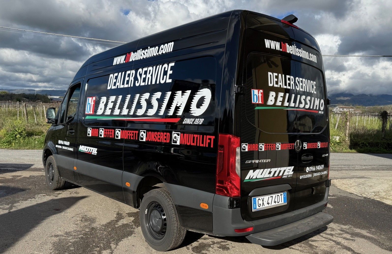 A black van is parked on the side of the road.