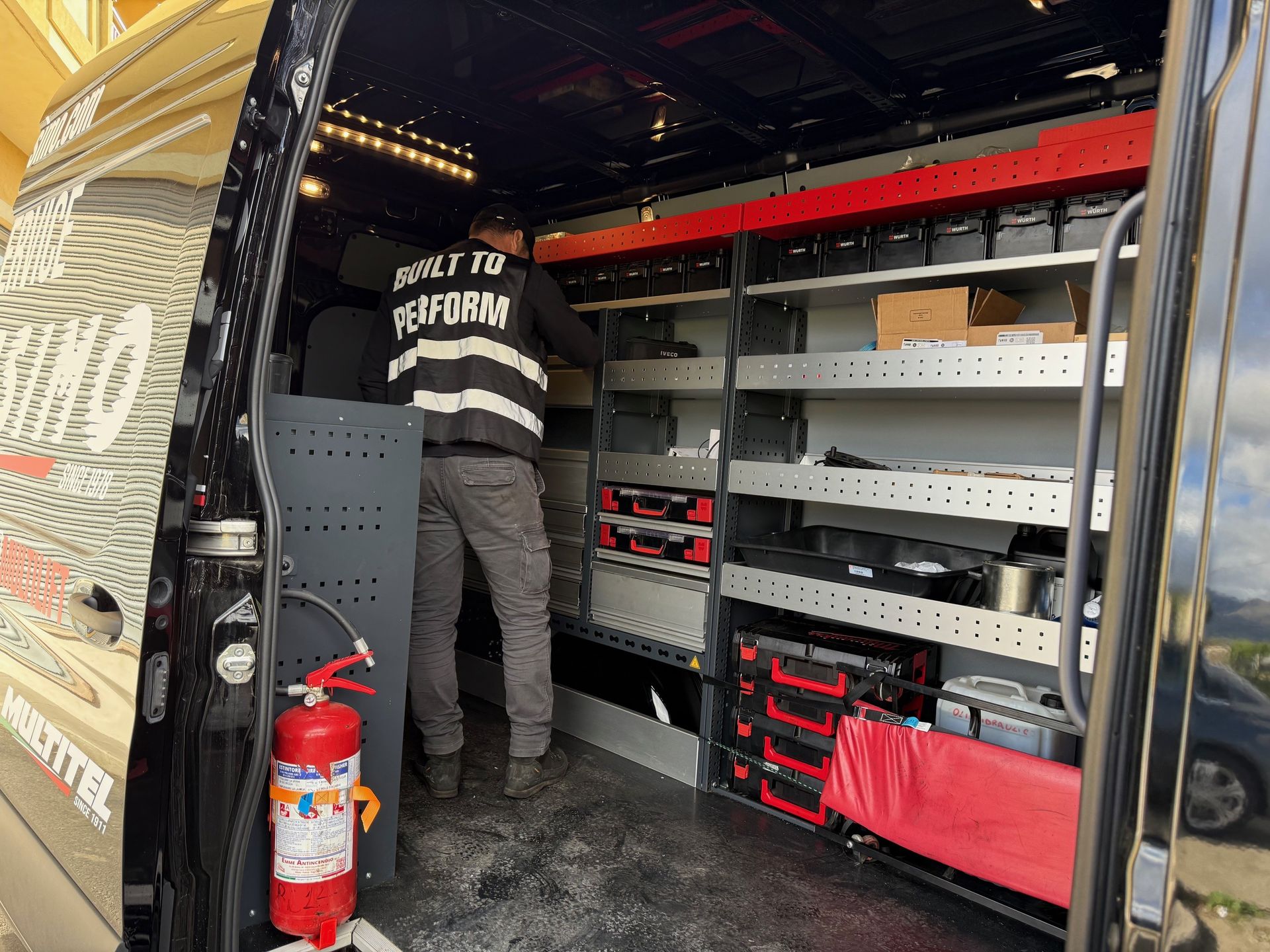 A man is standing in the back of a van.