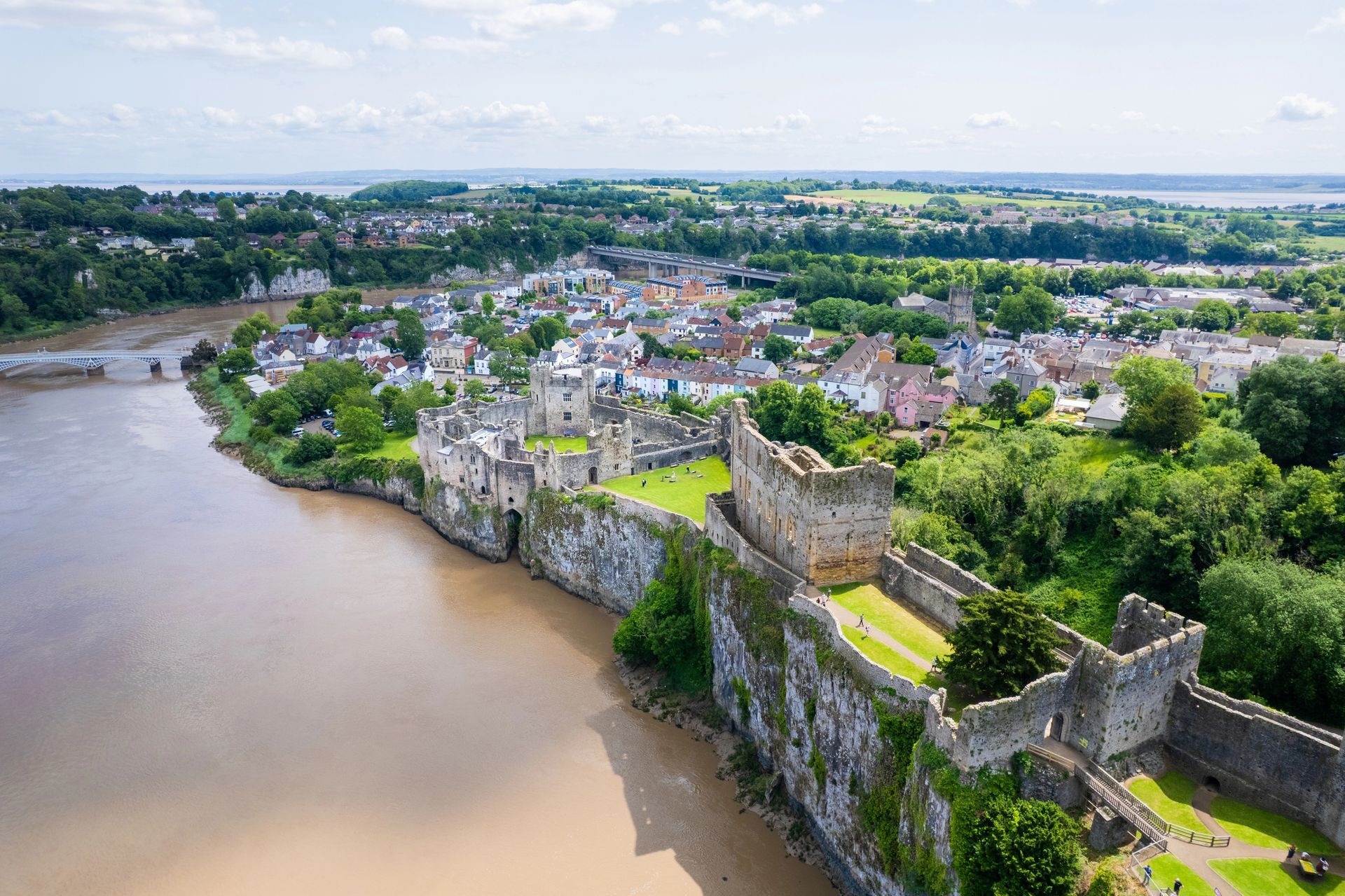 Ariel view of Chepstow town and the impressive Chepstow Castle on the banks of the River Wye towards the Severn Estuary.