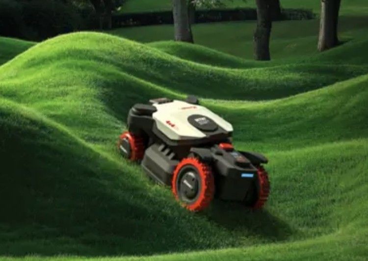 Robot tagliaerba su un prato verde brillante e ondulato