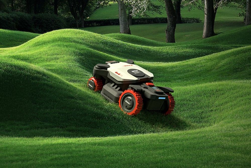 Un tosaerba compatto su un prato verde brillante e ondulato in un ambiente simile a un parco.