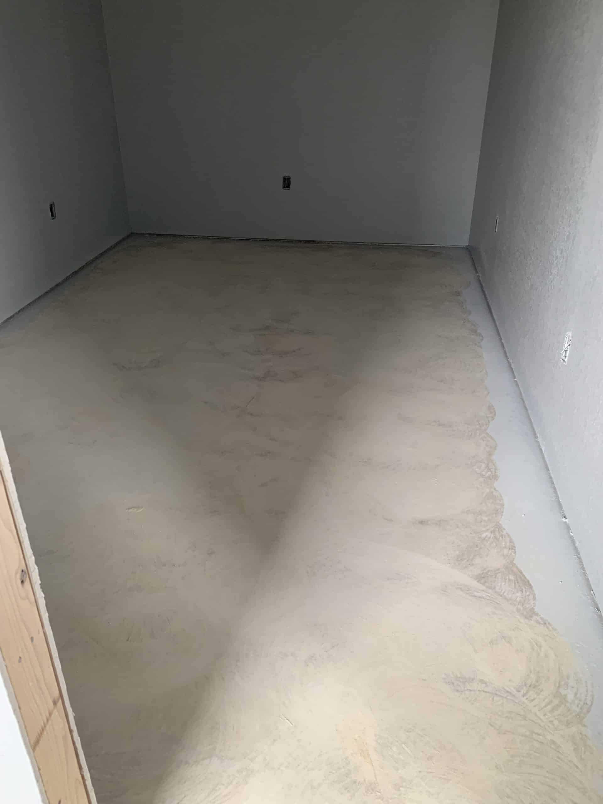Empty room with light-colored concrete floor and neutral walls.