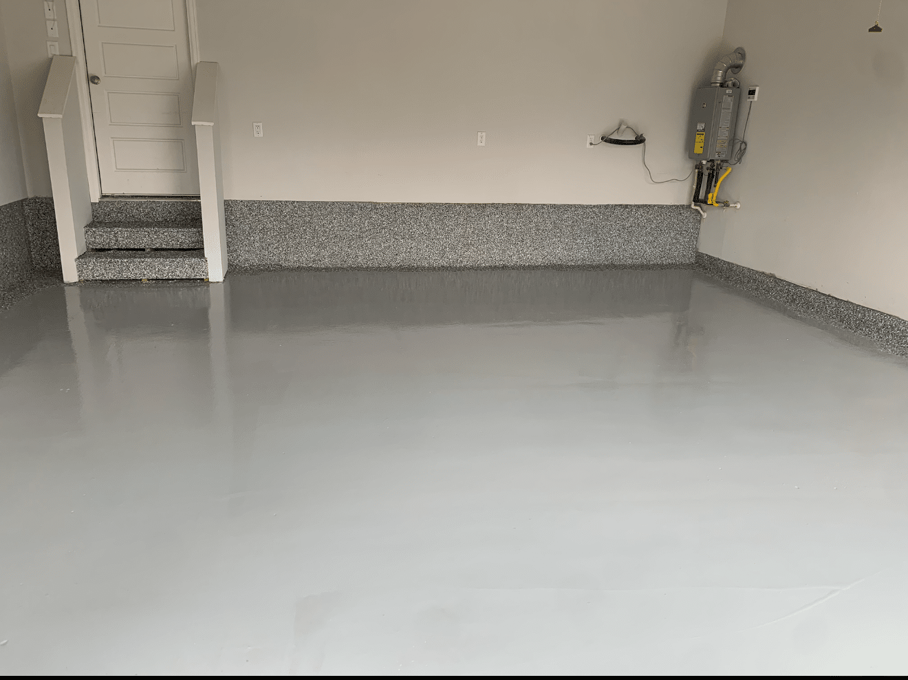 Grey epoxy garage floor with speckled border and stairs.