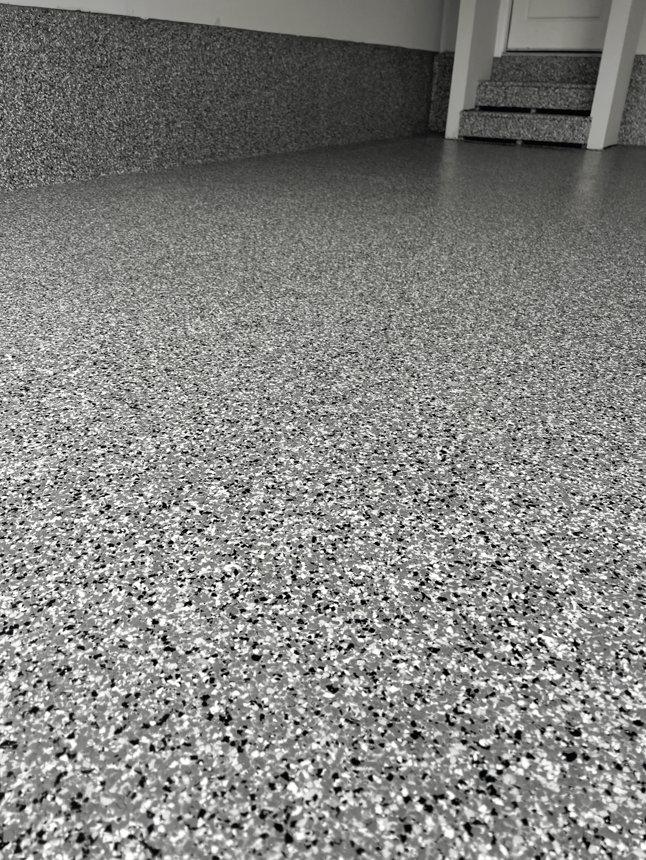 Gray and black speckled epoxy floor in a garage.