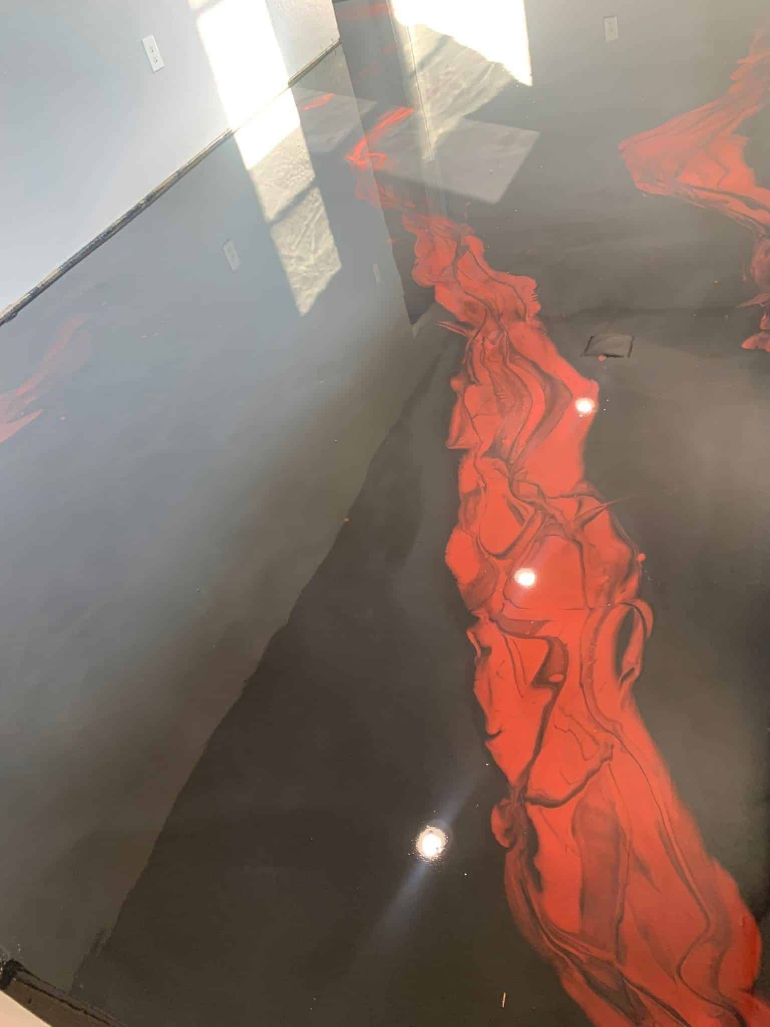 Black floor with flowing red, abstract design. Shiny surface.