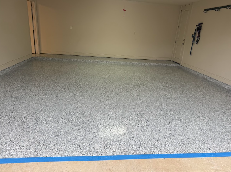 Garage interior with gray speckled epoxy floor and tan walls.