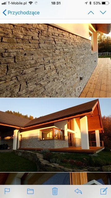 Stone-clad house exterior with a wooden roof and porch, bathed in warm sunlight.