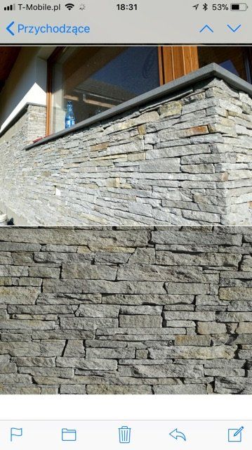 Stone wall corner with a dark gray cap. The lower section of the wall is also made of stacked stone.