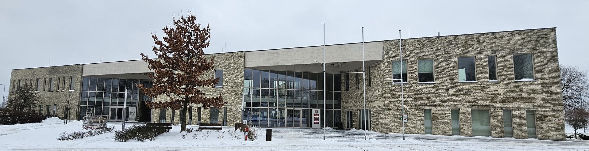Stone building in a snowy landscape, with windows and a large entrance.