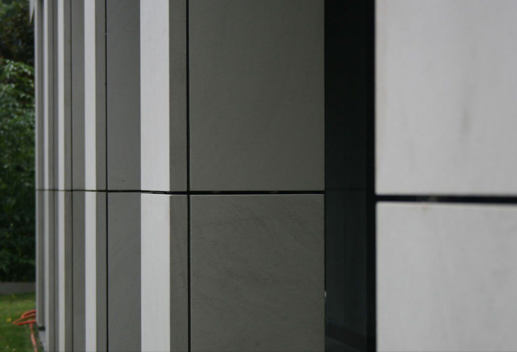 Close-up of a modern building exterior with gray and white vertical panels.
