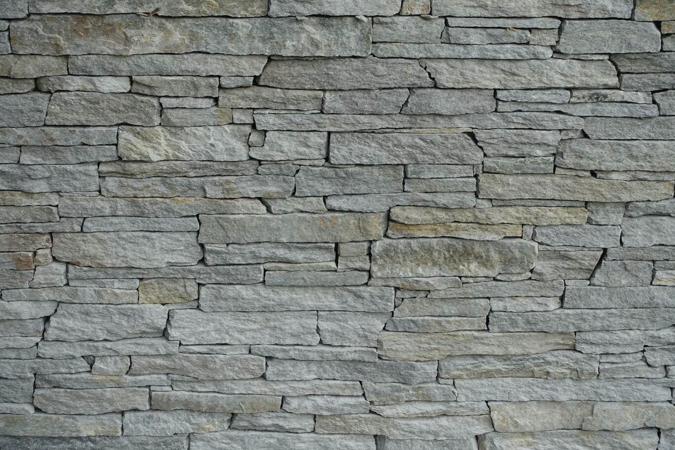 Gray stone wall with a layered, rectangular pattern.
