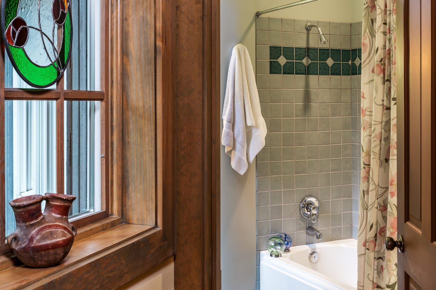 A bathroom with a tub , shower and window.