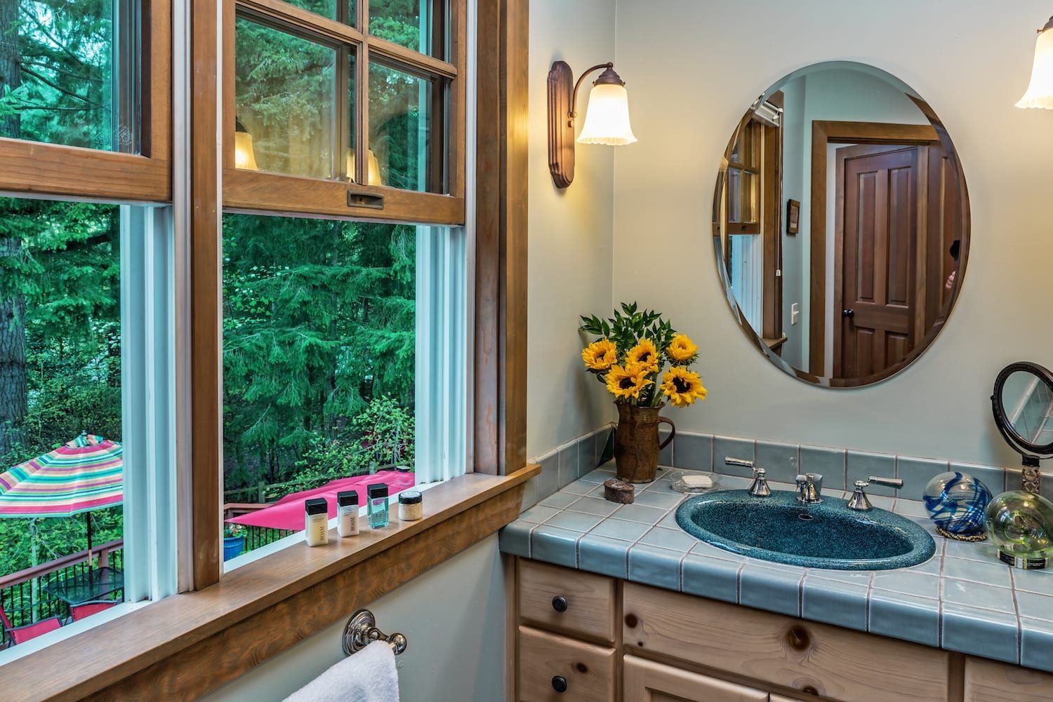 A bathroom with a sink , mirror , and window.