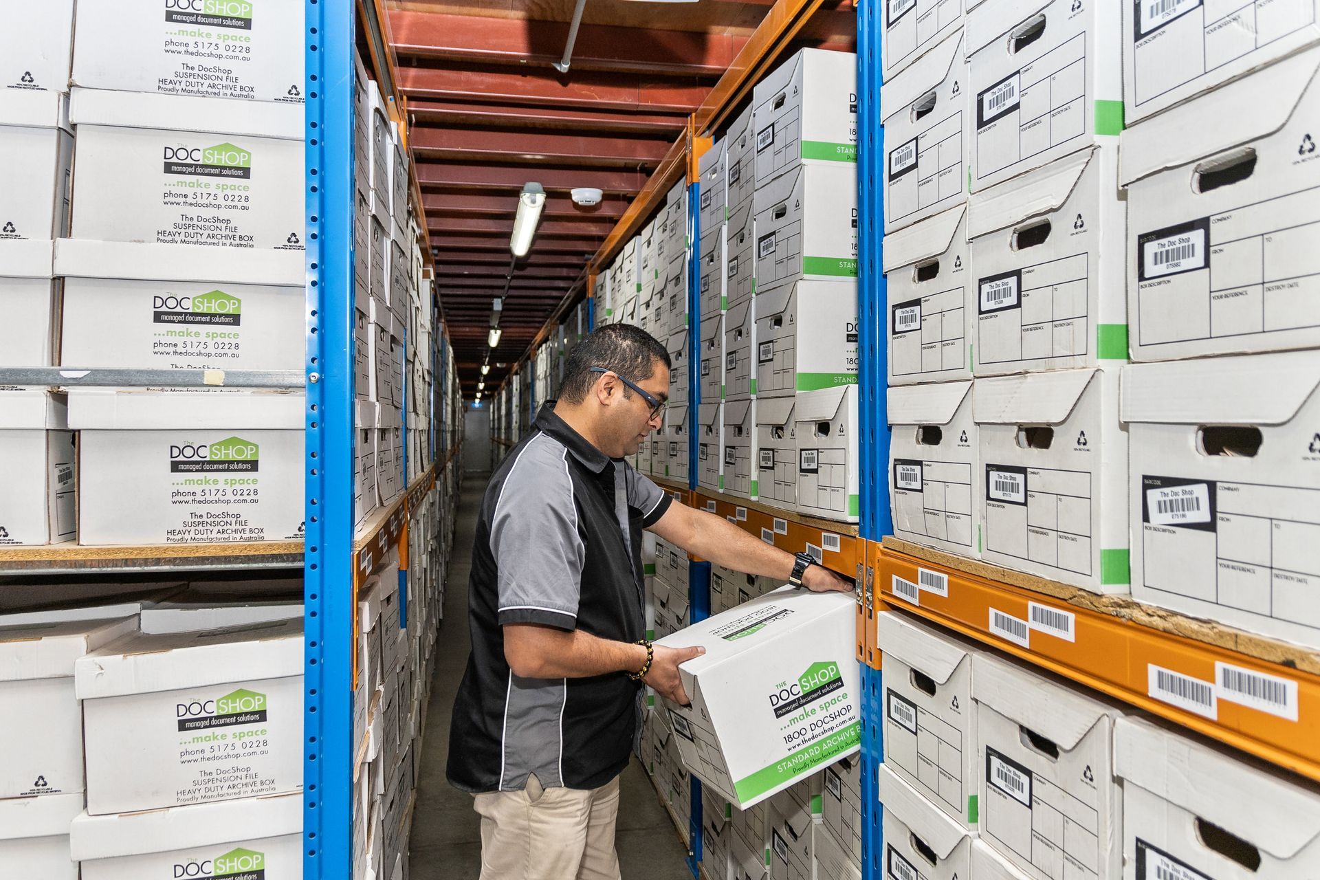 The DocShop team member retrieving archived business records from secure document storage shelves.