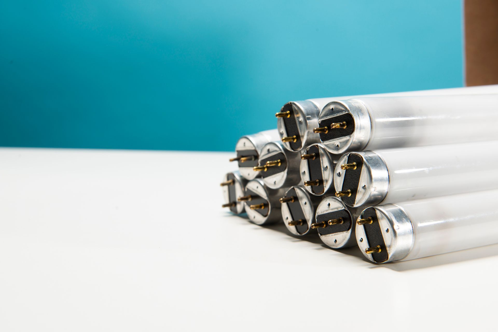 A bunch of fluorescent lights are stacked on top of each other on a table.