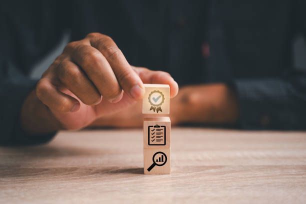 A person is holding a wooden block with icons on it.