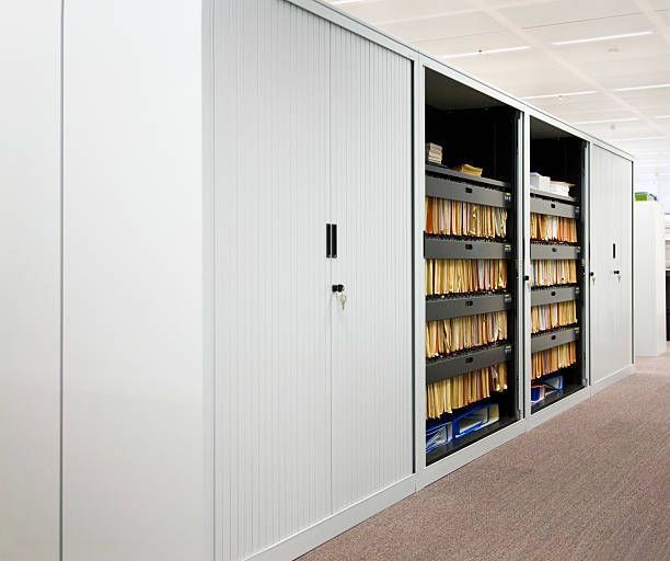A row of white cabinets filled with lots of files