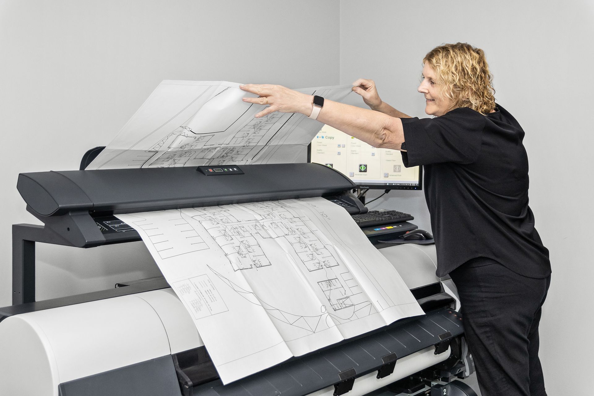 A person is using a heavy duty printer to scan a piece of paper.